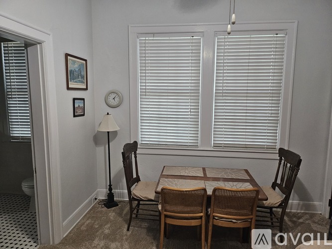 A dining room with a table and chairs.