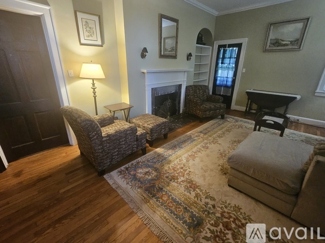 A living room with a fireplace and a rug on the floor.