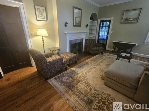 A living room with a fireplace and a rug on the floor.