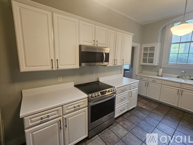 A kitchen with white cabinets and appliances.