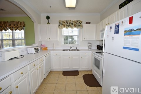 A kitchen with white appliances and cabinets.