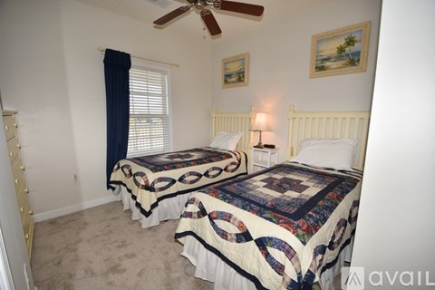 A bedroom with two beds and a ceiling fan.