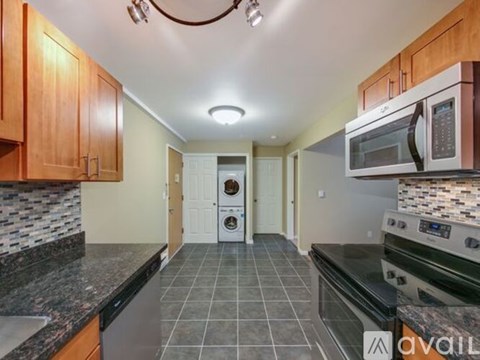 A kitchen with a black counter top and a white oven.