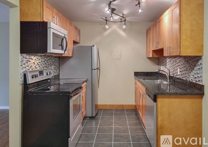 A kitchen with black appliances and wooden cabinets.