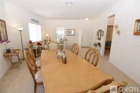 A dining room with a wooden table and chairs.