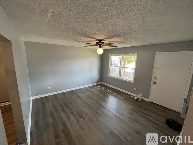 A room with a ceiling fan and a window.