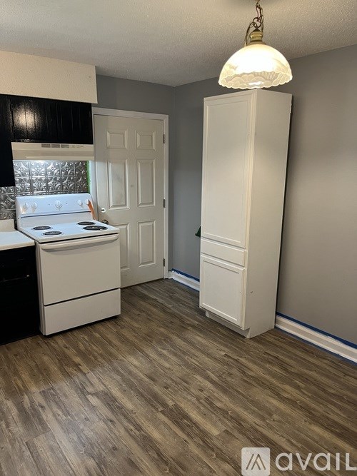 A kitchen with a white stove top oven and a white refrigerator.