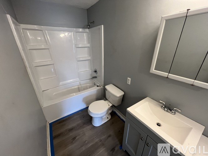 A white toilet sits next to a sink in a bathroom.
