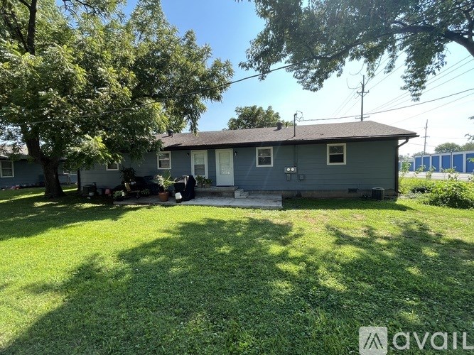 A house with a lawn and trees in front of it.
