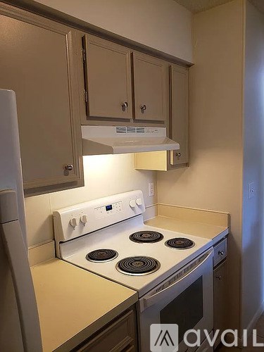 A kitchen with a stove top oven and a refrigerator.
