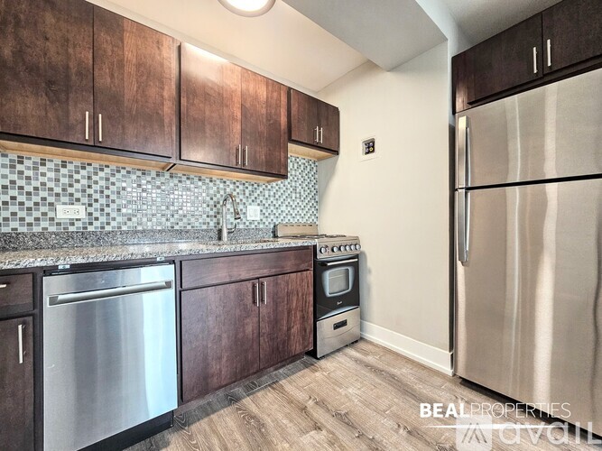 A kitchen with wooden cabinets and a stainless steel refrigerator.