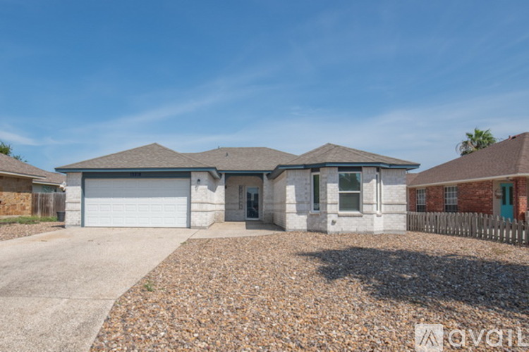 A house with a gravel driveway and a garage door is for sale.