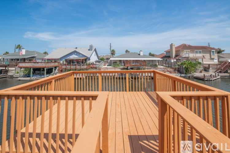 A wooden deck overlooks a marina with boats and buildings.