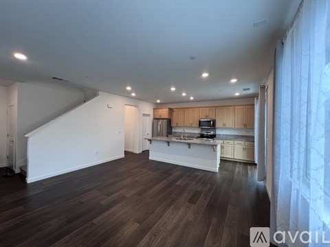 A spacious living room with a staircase leading to the upper level.