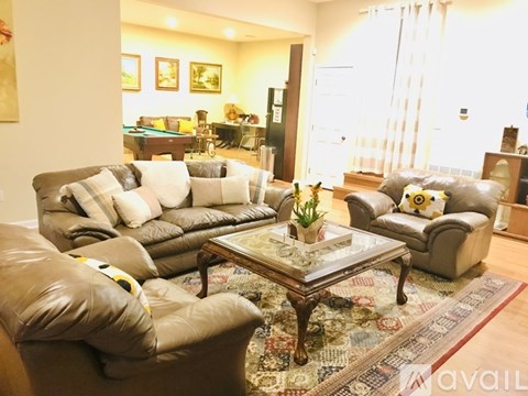 A living room with a pool table and leather couches.