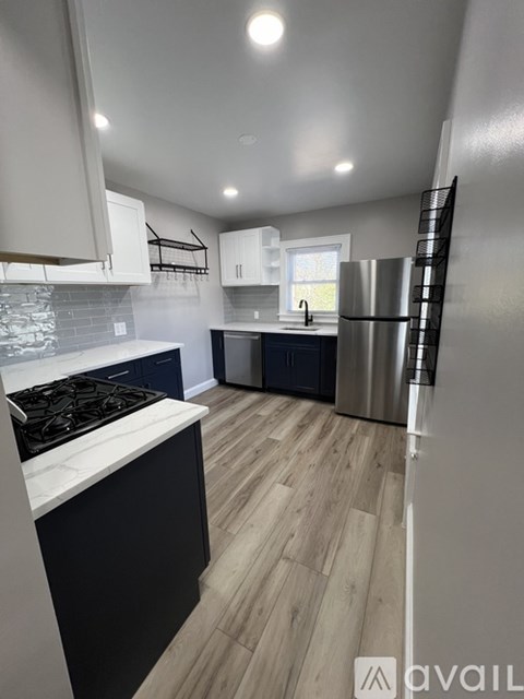 A kitchen with a stove top oven and a refrigerator.