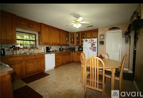 A kitchen with wooden cabinets and a table with chairs.