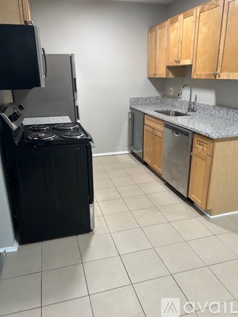 A kitchen with black appliances and wooden cabinets.
