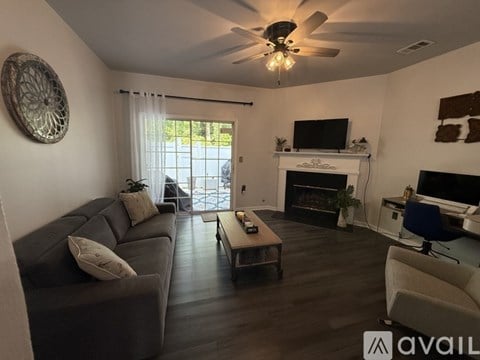 A living room with a grey couch and a fireplace.