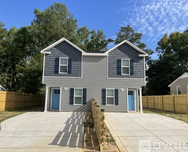 A two-story house with a grey exterior and a blue door.