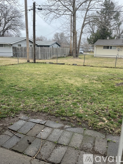 A backyard with a broken concrete slab in the foreground.