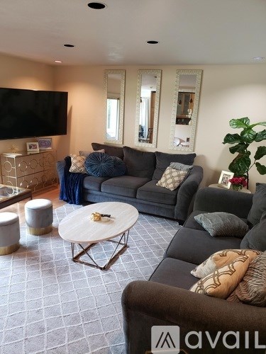 A living room with a grey couch and a white coffee table.
