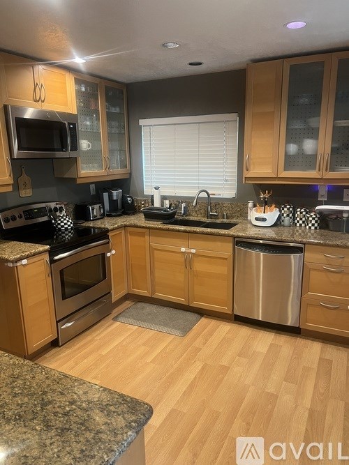 A kitchen with wooden cabinets and granite countertops.