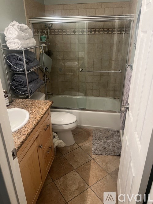 A bathroom with a toilet, sink, and shower.