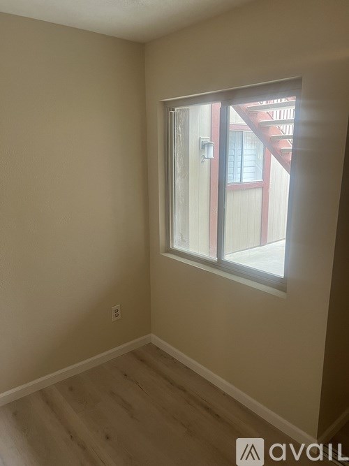 A room with a window and wooden flooring.