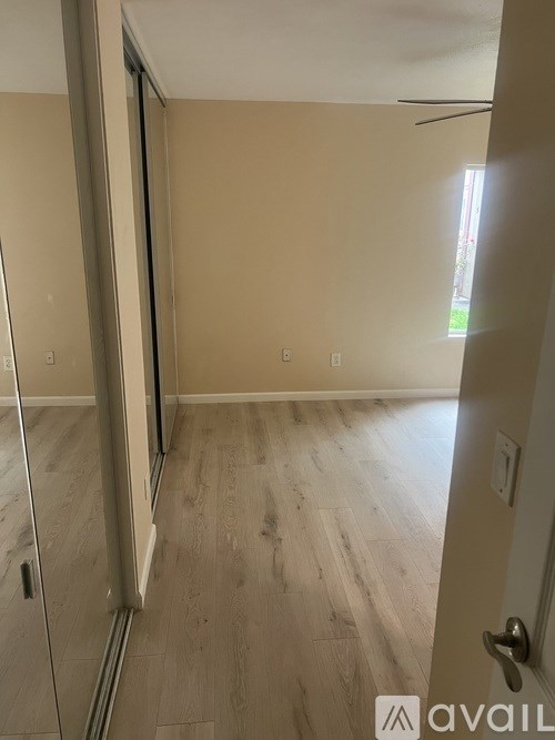 A room with wooden flooring and a sliding door.