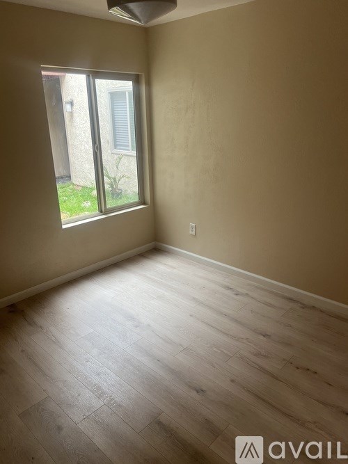 A room with wooden flooring and a window.