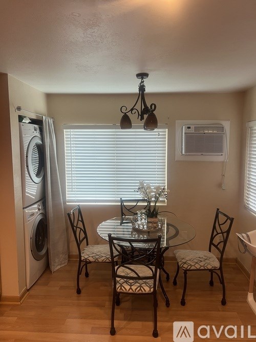 A small dining room with a glass table and chairs.