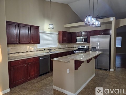 A kitchen with brown cabinets and a beige island.