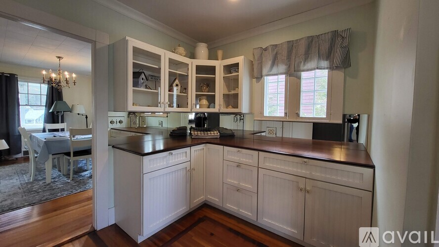 A kitchen with white cabinets and a black countertop.