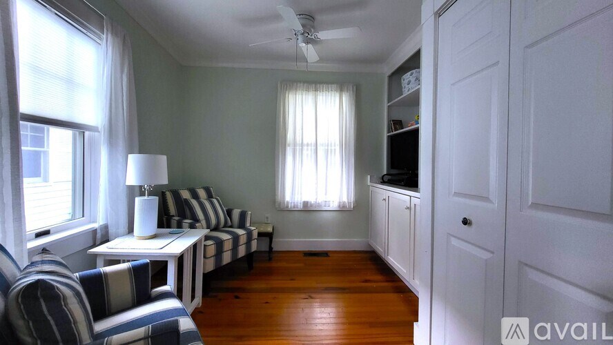 A living room with a striped couch and a white table.