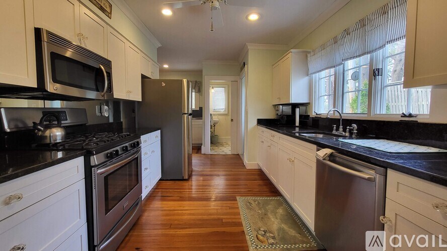 A kitchen with black countertops and white cabinets.