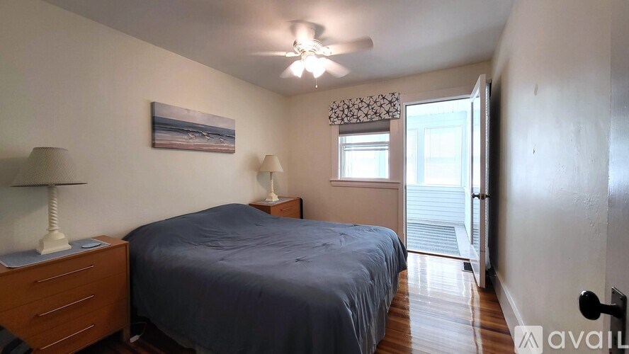 A bedroom with a bed, two lamps, and a painting on the wall.