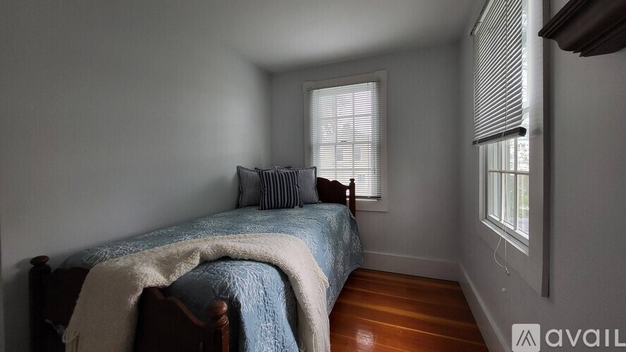 A bedroom with a bed, pillow, and blanket.
