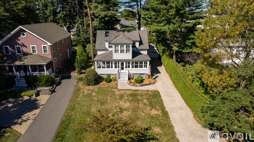 A house with a red roof is surrounded by greenery.