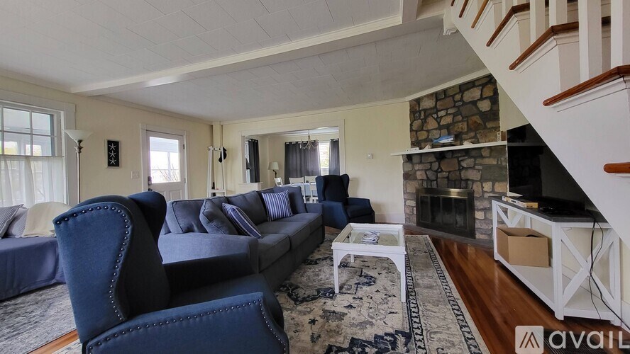 A living room with a blue couch and a fireplace.