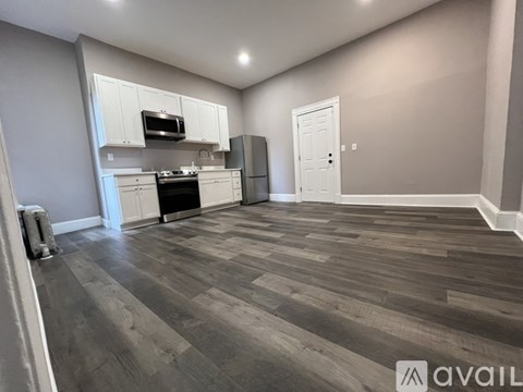 A kitchen with a refrigerator, microwave, and oven.