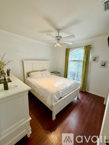 A bedroom with a bed, dresser, and window.