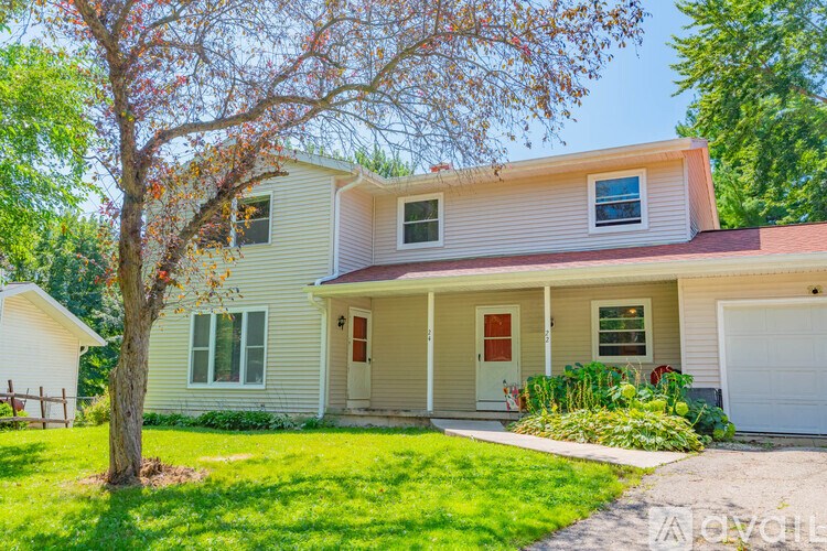 A house with a red door and a tree in front of it.