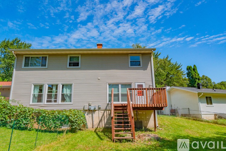 A house with a beige exterior and a wooden deck.