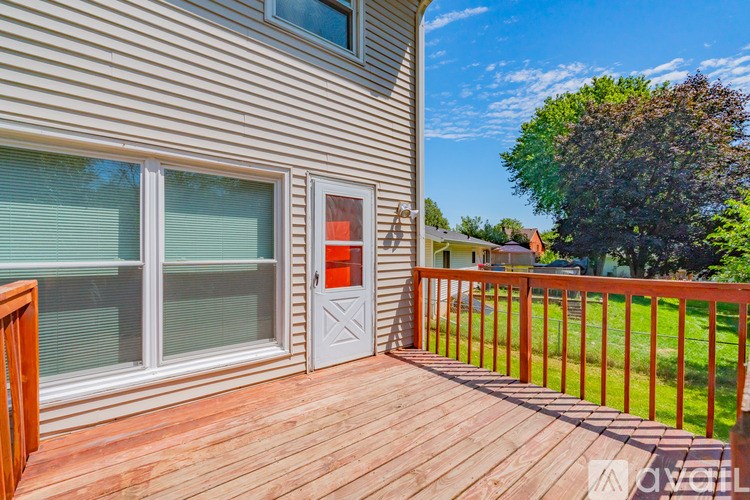 A deck with a red railing and a white door.