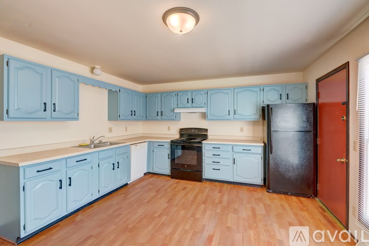A kitchen with blue cabinets and wooden floors.