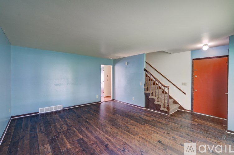 A room with wooden floors and a staircase.