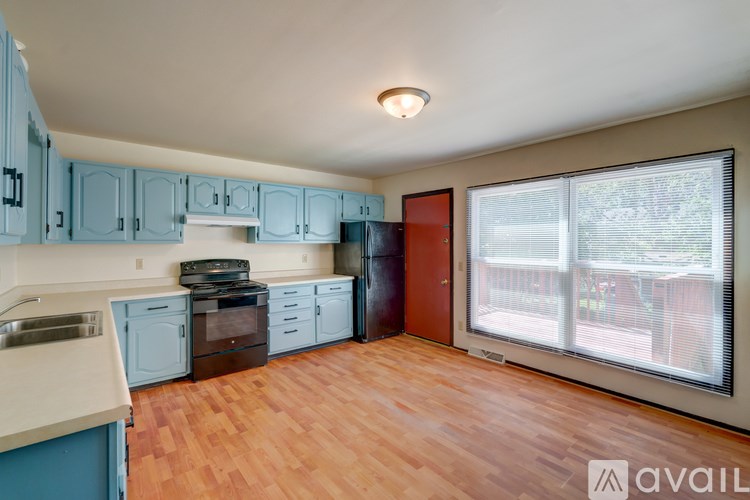 A kitchen with blue cabinets and wooden floors.