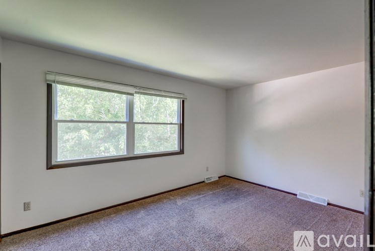 A room with a window and carpeted floor.