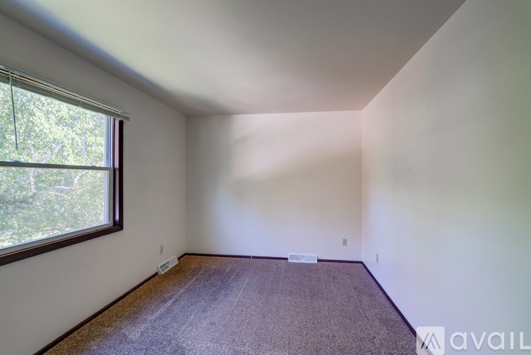 A room with a window and carpeted floor.